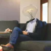 Mann mit Glühbirne als Kopf vor dem Laptop